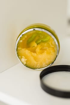 Orange body scrub with sugar and oil in glass jar copy space. Homemade cosmetic for peeling and spa care