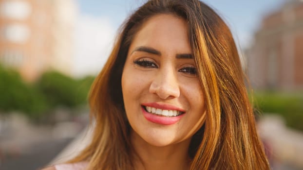 Hispanic beauty adult woman looks at camera and smiles in the street
