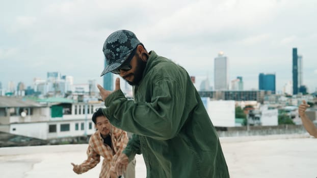 Professional break dance team practice B-boy dance while multicultural friends at rooftop. Young modern dancing group doing hip hop movement. Style,fashion,action. Outdoor sport 2024. Endeavor.