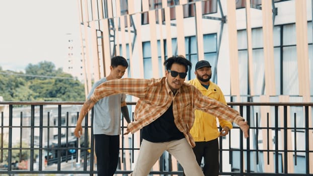 Hip hop team dance break dance while multicultural friend surrounded and clapping hands to cheer or encourage his friend to dance. Active and energetic street dance. Outdoor sport 2024. Endeavor.