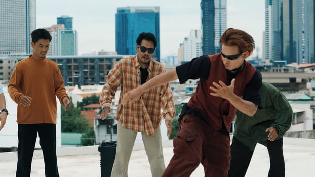 Hispanic hipster dancing surrounded by multicultural friend at city view with blue sky. Group of street dancer performing at rooftop. Active, fun, happy atmosphere. Outdoor sport 2024. Endeavor.