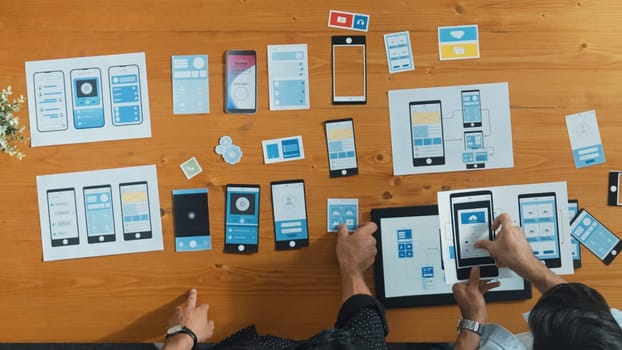 Top view of software developer working on Ux Ui design while team working together to brainstorm and develop wireframe prototype designing at creative digital company. Teamwork concept. Convocation.