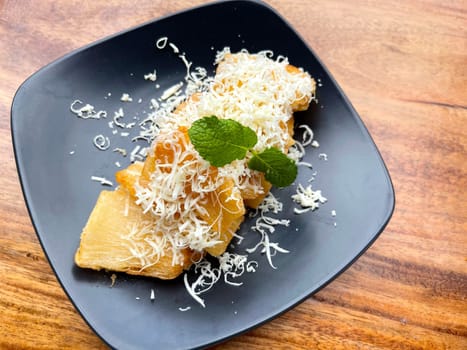 fried cassava with topping cheese on top, Indonesian traditional food, good for tea time or snack