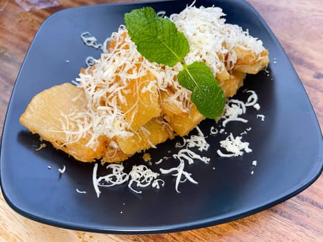 fried cassava with topping cheese on top, Indonesian traditional food, good for tea time or snack