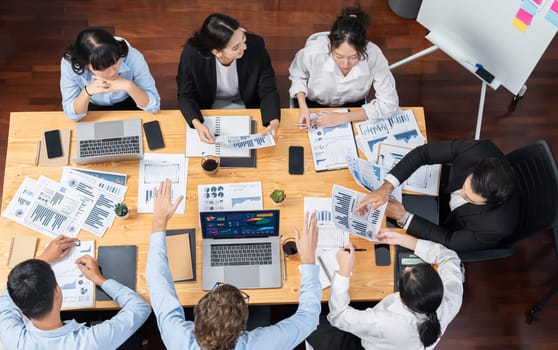 Panorama top view diverse group of business analyst team analyzing financial data report paper on meeting table. Chart and graph dashboard by business intelligence analysis. Meticulous