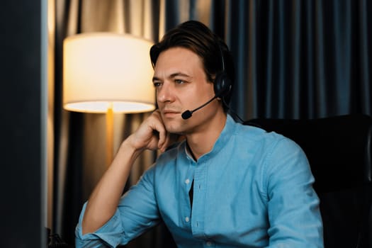 Call center consulting with customers on headphones on monitor in business paragraph with typing on pc with dynamic data marketing analysis planning at modern home office at night time. Pecuniary.