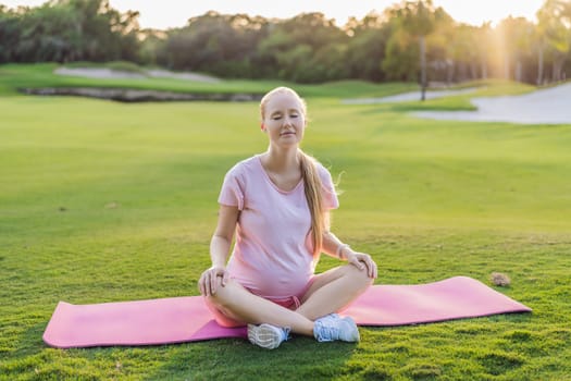 Energetic pregnant woman takes her workout outdoors, using an exercise mat for a refreshing and health-conscious outdoor exercise session.