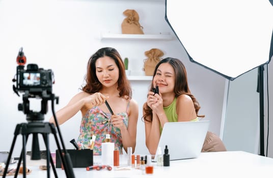 Asian Woman influencer shoot live streaming vlog video review makeup uttermost social media or blog. Happy young girl with cosmetics studio lighting for marketing recording session broadcasting online