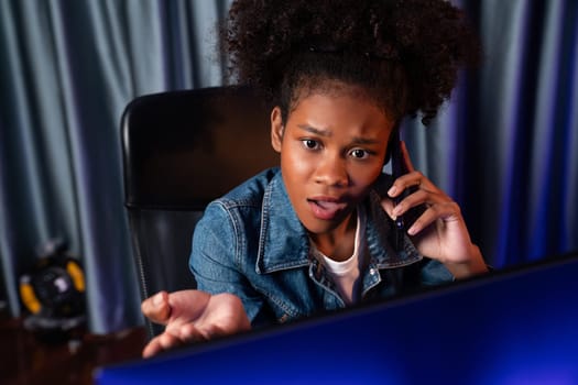 Working African woman blogger concentrating laptop screen, making a phone call with serious face, searching marketing data analysis, conclusion overall document on database for report. Tastemaker.