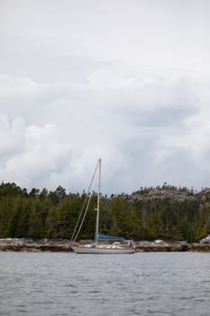 A beautiful sailboat in a remote anchorage with mountains in the background, Central coast of British Columbia, Canada