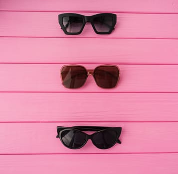 Summer abstract background mockup template free copy space for text pattern sample top view above on pink wooden board. blank empty area for inscription. Couple Stylish black sunglasses fashionable