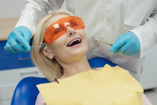 Woman smiling during her dental treatment at dentist.