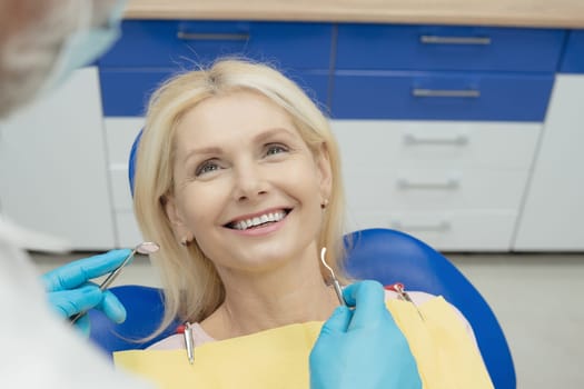 Woman smiling during her dental treatment at dentist.