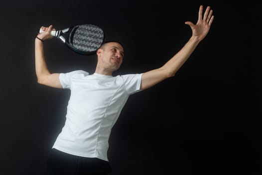 Man ready for paddle tennis serve in studio shot. High quality photo