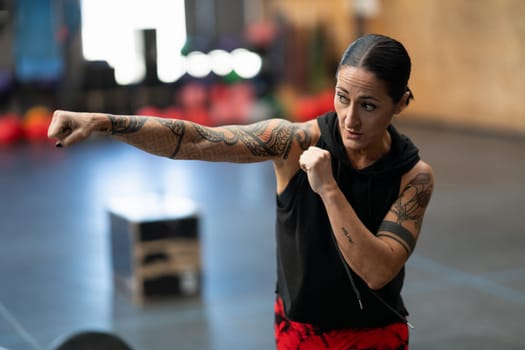 Close-up of a mature sportive woman shadowboxing in a cross training gym