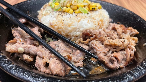 selective focus grilled beef steak with korean sauce bulgogi on top of rice with slice of pepper and sweet corn - korean and japanese food style in a restaurant