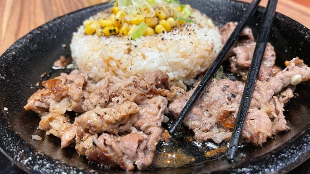 selective focus grilled beef steak with korean sauce bulgogi on top of rice with slice of pepper and sweet corn - korean and japanese food style in a restaurant