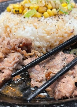 selective focus grilled beef steak with korean sauce bulgogi on top of rice with slice of pepper and sweet corn - korean and japanese food style in a restaurant