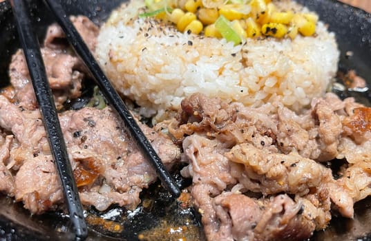 selective focus grilled beef steak with korean sauce bulgogi on top of rice with slice of pepper and sweet corn - korean and japanese food style in a restaurant