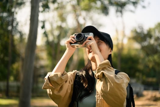 Photographer traveler taking photo with camera in nature. Holiday, travel and lifestyle concept.