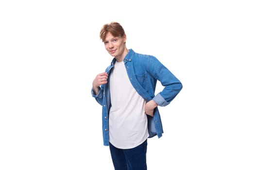 young red-haired guy in a blue shirt and white t-shirt shows a mockup for advertising.