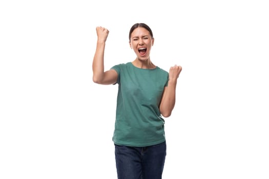 young emotional brunette woman in a t-shirt and jeans on a white background with copy space.