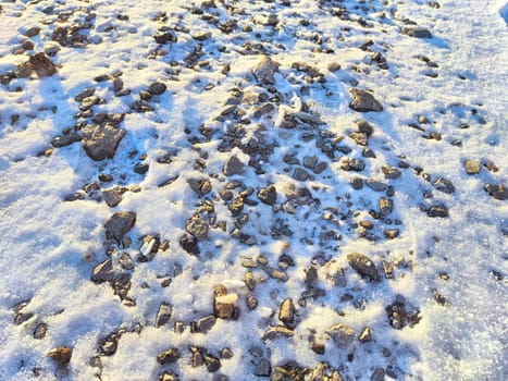 Texture of small stones with snow. Background of pebbles and ice. Abstract background, texture, pattern, frame, place for text and copy space