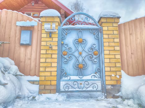 New gate, entrance to a private territory on a winter day and snow. Metallic texture and background. Fence