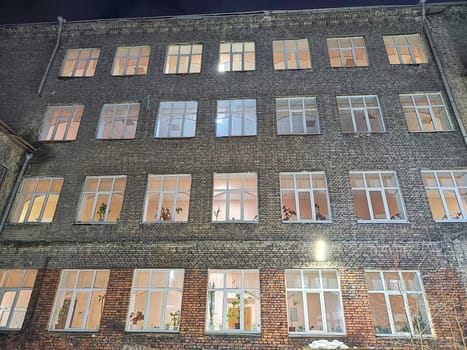 Lit windows of brick office building after dark. Illuminated Office Building at Nighttime