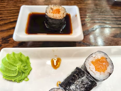 Sushi rolls with fresh ingredients served on platter. Japanese Sushi Rolls on White Plate With Ginger Garnish. Blurred and Partial focus