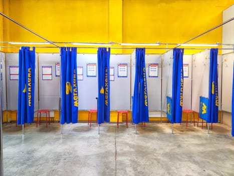 Kirov, Russia - January 04, 2024: Fitting Booths at Meghand Store With Blue Curtains and Red Stools. Blue curtained changing areas with red stools at Megahand store