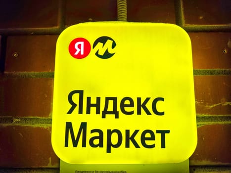 Kirov, Russia - February 06, 2024: Close-up of Yandex Market logo against brick wall. Yandex Market Logo on brick red Background