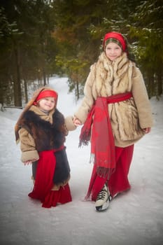 Teen and little girl in thick coat in cold winter day in a forest. Medieval peasant sisters collecting firewood. Photoshoot in stile of Christmas fairy tale