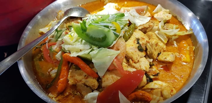 Selective focus Indonesian traditional dish mangut fish, made from smoked fish, cooked with coconut milk sauce mixed with spices, tomato, turmeric, and chillies with various seasonings