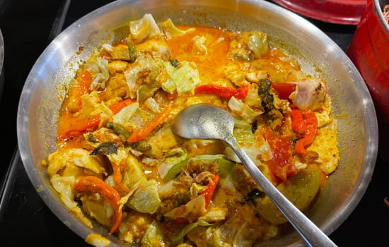 Selective focus Indonesian traditional dish mangut fish, made from smoked fish, cooked with coconut milk sauce mixed with spices, tomato, turmeric, and chillies with various seasonings