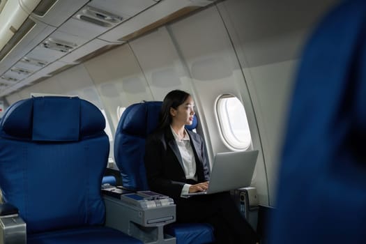 Beautiful Asian businesswoman working with laptop in aeroplane. working, travel, business concept.