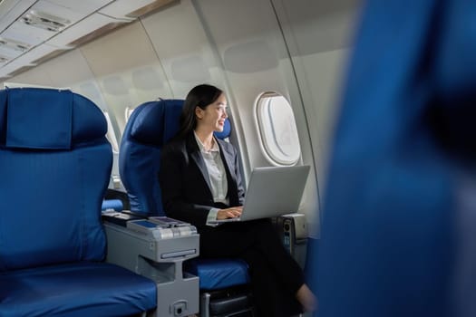 Beautiful Asian businesswoman working with laptop in aeroplane. working, travel, business concept.