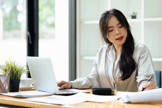 accountant working on desk using calculator for calculate finance report in office.