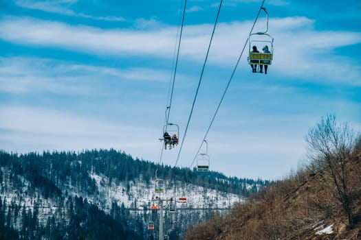 mountains in snow with ski lift chairs.