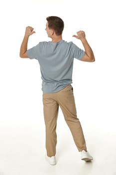 happy guy looking pointing to his back on white studio background