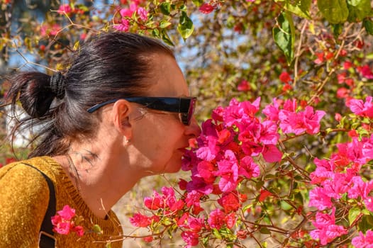 woman smelling bougainvillea flowers in cyprus 2