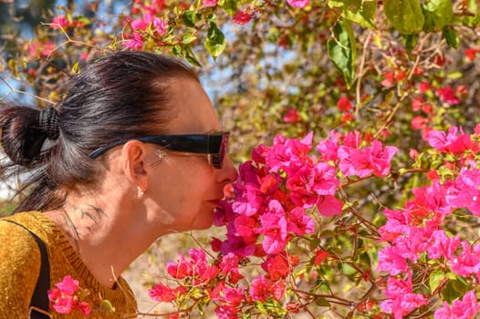 woman smelling bougainvillea flowers in cyprus 4