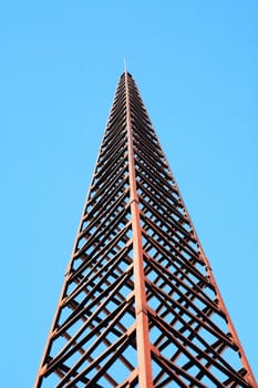 Old metal tower against blue sky background