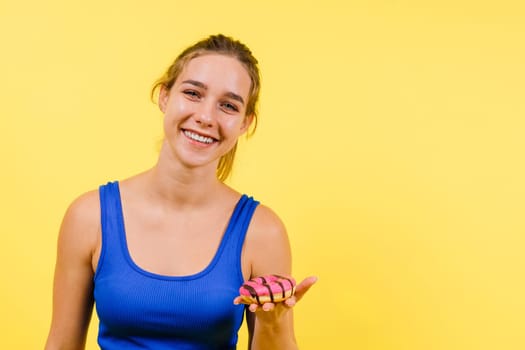 Young cute sport woman eating donut cake in studio background