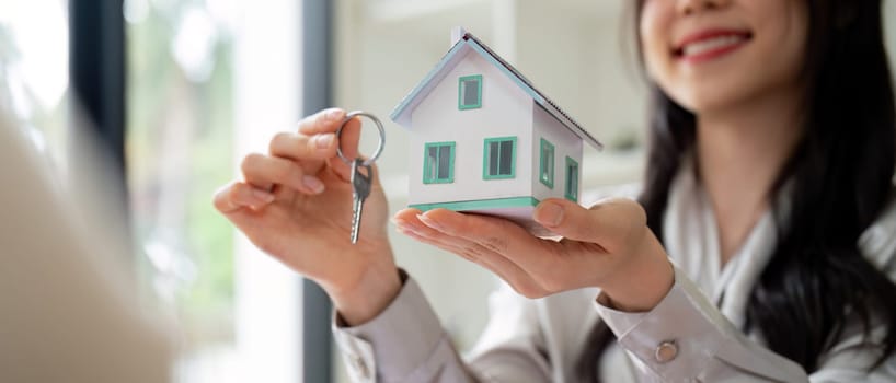 Real estate agent hand over property or new home keys to a customer.