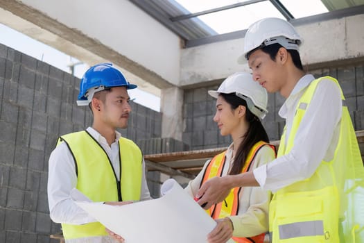 Civil engineer teams meeting working together wear worker helmets hardhat on construction site in modern city. Foreman industry project manager engineer teamwork. Asian industry professional team.