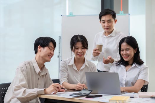 team of Asian businessmen meets to brainstorm ideas about office work management in an office conference room..