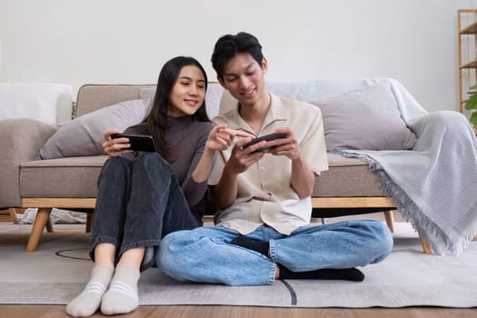 young Asian couple spends their free time relax together in the living room on vacation..