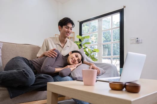 young Asian couple spends their free time relax together in the living room on vacation..