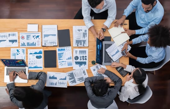 Panorama top view multiracial analyst team use BI dashboard display on laptop screen, analyzing financial data for strategic decision. Fintech analyzes marketing indicators. Concord